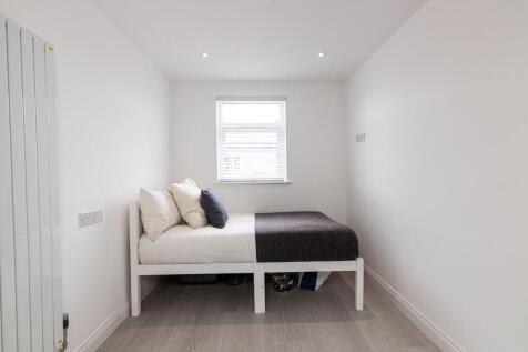 Bright, simply furnished single bedroom with a ...