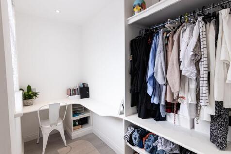 Bright, neatly organised bedroom nook with a bu...