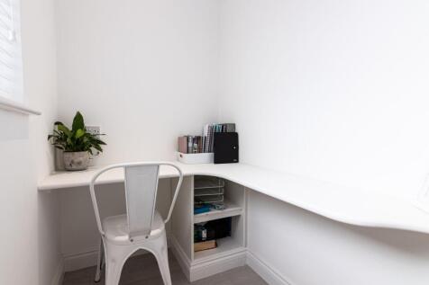 Bright, minimalist corner workspace with a buil...