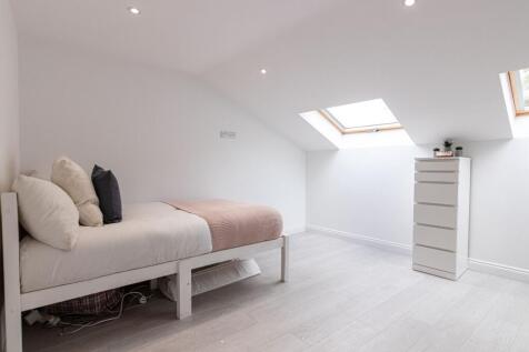 Bright, minimalist attic bedroom with a single ...