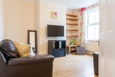 Bright, well-kept living room with a wall-mount...