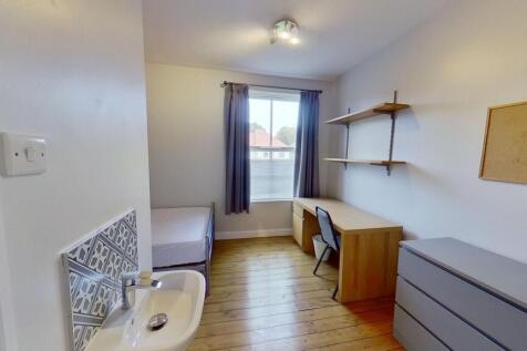 Bright, tidy bedroom with wooden floors, a stud...