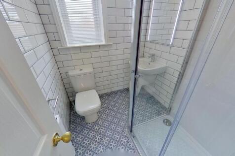 Bright, modern bathroom with patterned floor ti...