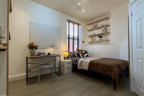A bright and inviting double bedroom with a coz...