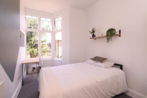 A bright and inviting double bedroom with large...