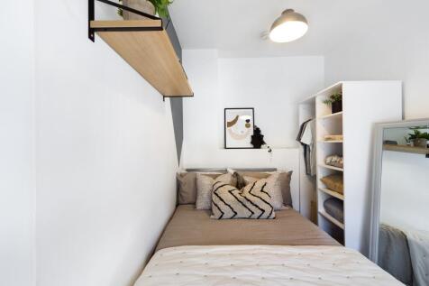 A bright and stylish double bedroom featuring m...