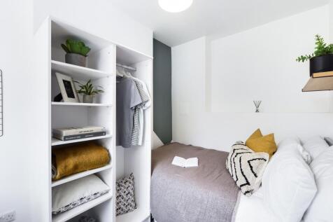 A cozy and well-lit double bedroom with stylish...