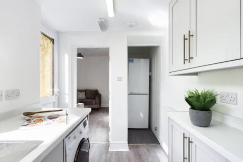 A bright and modern kitchenette with clean surf...