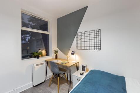 A bright and tidy double bedroom featuring a st...