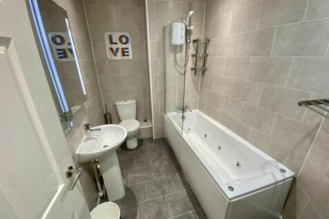 A spacious and modern bathroom featuring a rela...