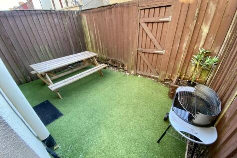 A charming garden space featuring a picnic tabl...