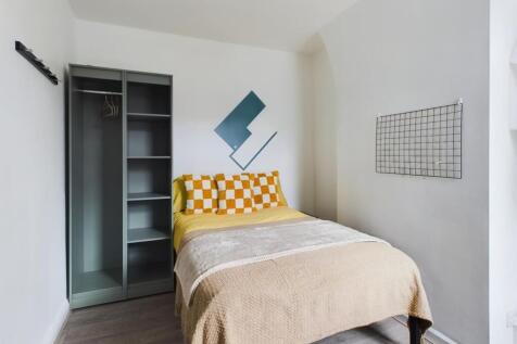 A bright and tidy double bedroom featuring mode...