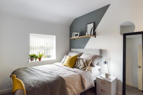 A bright and inviting double bedroom with styli...