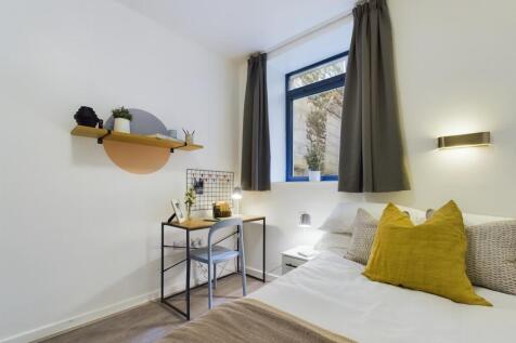 A bright and stylish double bedroom featuring a...