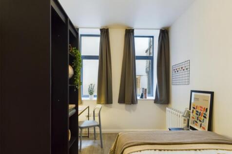 A bright and inviting double bedroom with styli...