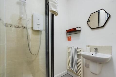 A modern and tidy bathroom featuring a shower a...