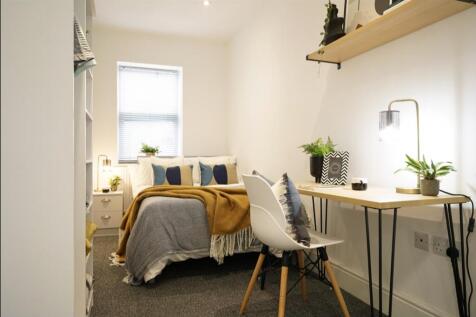 A bright and stylish double bedroom featuring a...