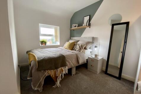A cozy and well-lit double bedroom with stylish...