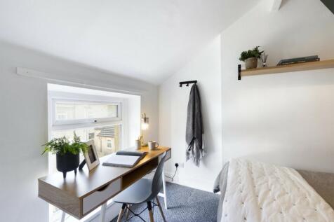 A bright and tidy double bedroom featuring a st...