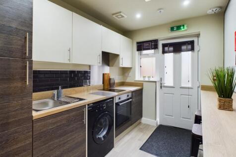 A modern and clean kitchenette with ample stora...