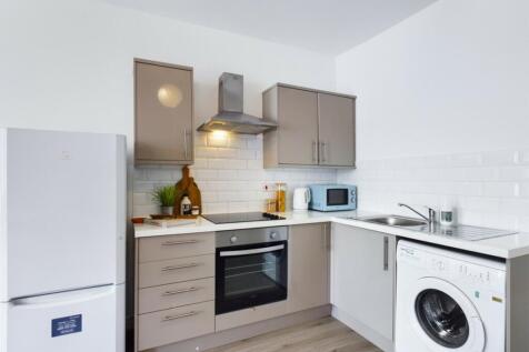 A modern and tidy kitchenette featuring ample s...