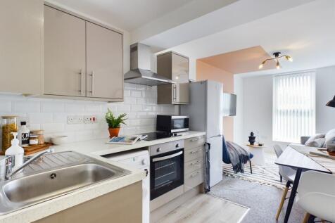 A modern and tidy kitchenette with ample natura...