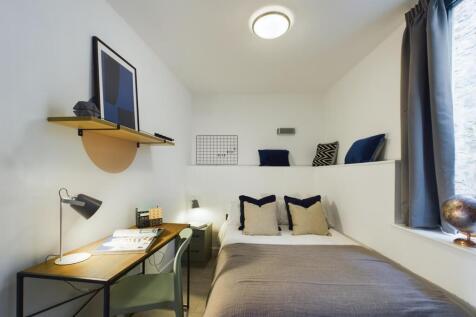 A bright and stylish double bedroom featuring a...