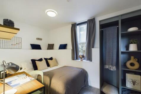 A bright and tidy double bedroom featuring styl...