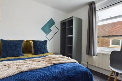 A cozy and well-lit double bedroom featuring st...