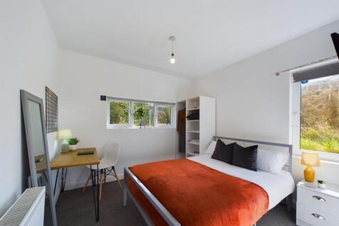 A spacious, well-lit master bedroom featuring a...