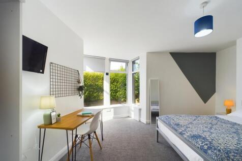 Bright and welcoming bedroom featuring a comfor...