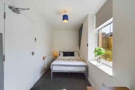 A bright and tidy bedroom featuring a comfortab...