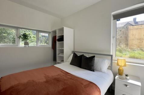 A bright and welcoming bedroom featuring a doub...