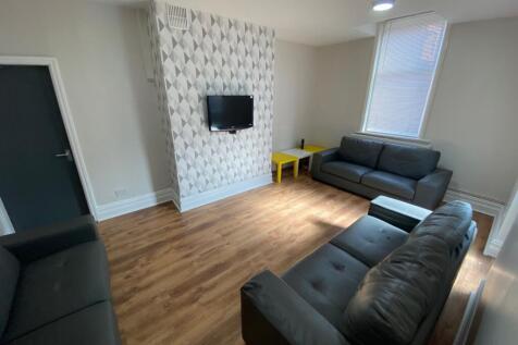 A stylish and spacious living room with ample n...