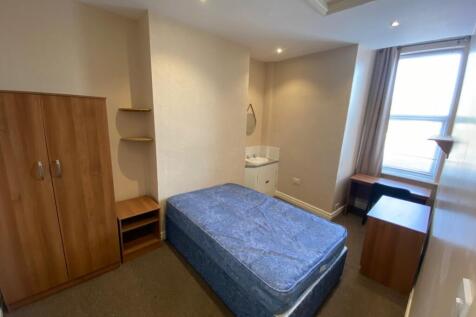 A spacious and well-lit double bedroom with ess...