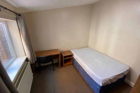 A bright and tidy double bedroom with a desk an...