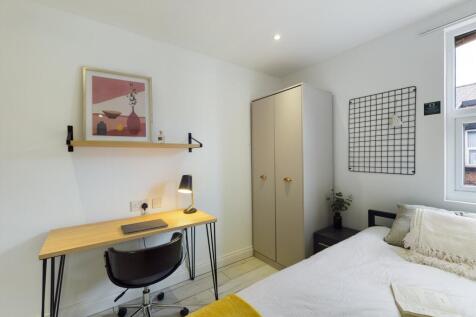 A bright and tidy double bedroom featuring a wo...