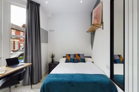 A bright and modern double bedroom featuring st...