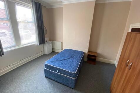 A spacious and well-lit double bedroom with mod...