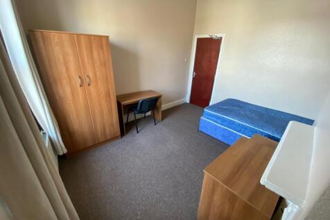 A tidy and inviting single bedroom featuring a ...