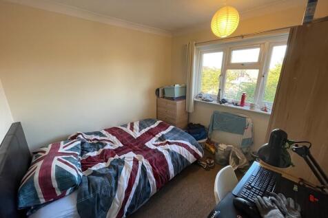 A cozy bedroom featuring a bed with a Union Jac...