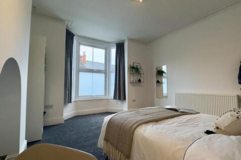 A spacious and bright double bedroom with large...