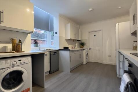 A bright and modern kitchen featuring ample sto...