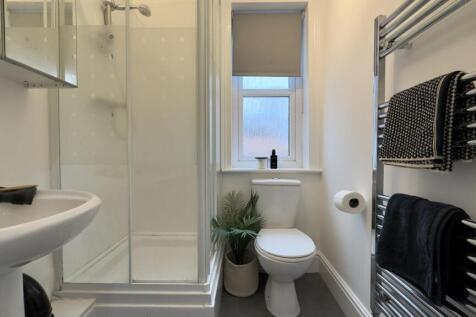 A modern and tidy bathroom featuring a sleek sh...