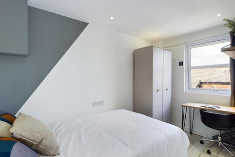 A bright and tidy double bedroom featuring mode...