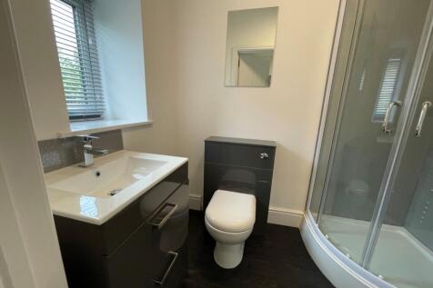 A modern and immaculate bathroom featuring a sl...