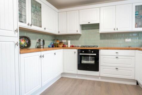 A bright and modern kitchen featuring ample sto...