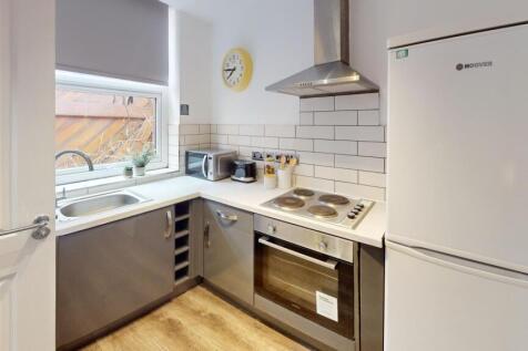 A modern and tidy kitchenette with ample natura...