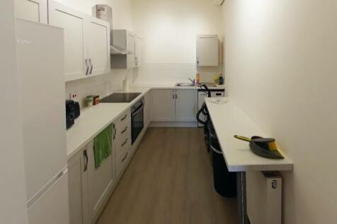 A bright and tidy kitchenette with ample storag...