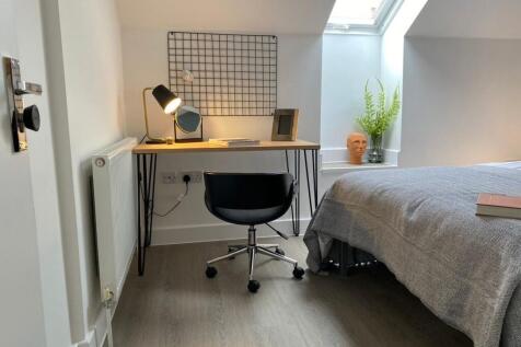 A bright and tidy single bedroom featuring a co...